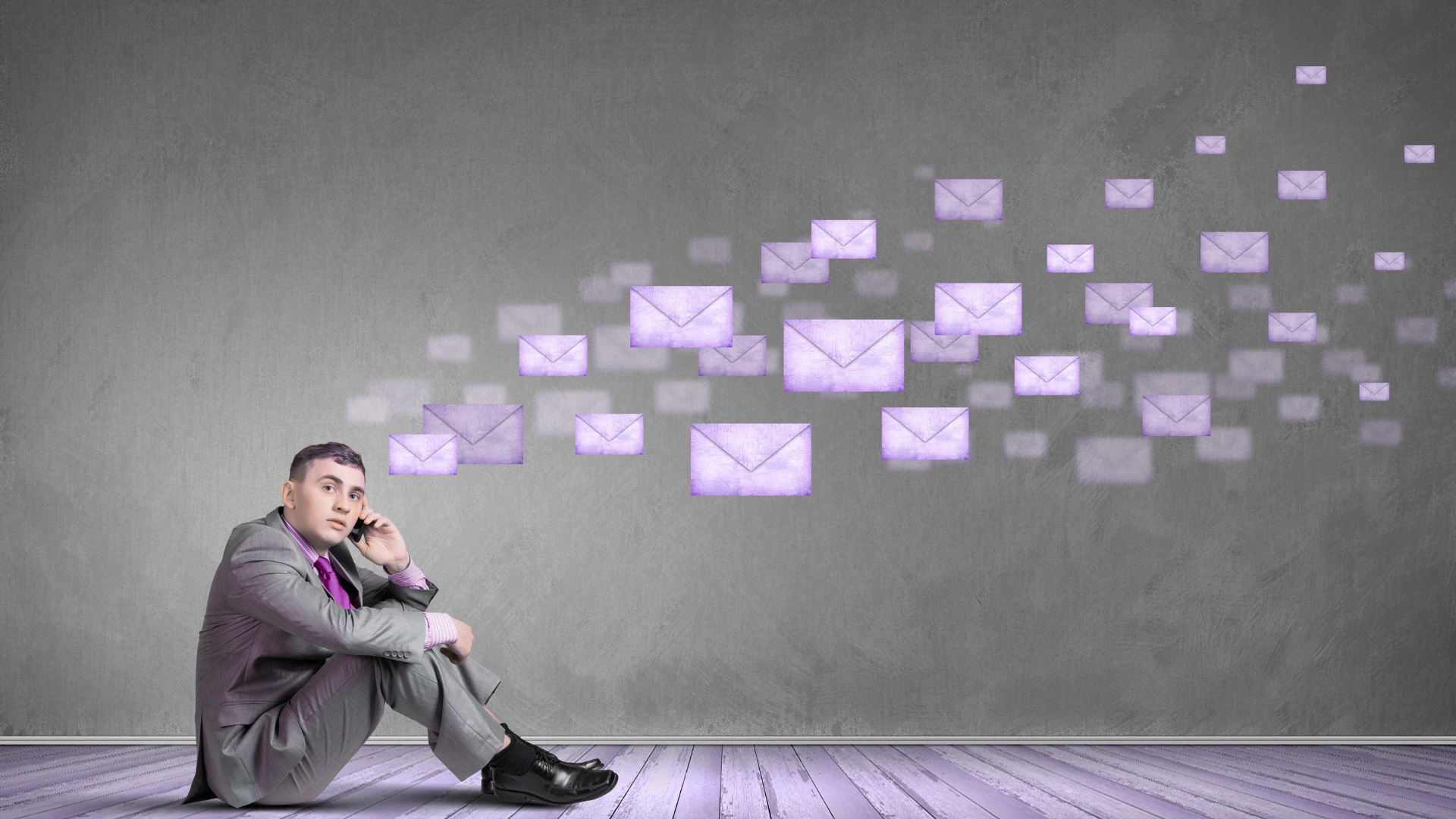 Geschäftsmann sitzt nachdenklich vor grauer Wand, während digitale E-Mail-Symbole vorbeiziehen – Symbolbild für misslungene interne Unternehmenskommunikation