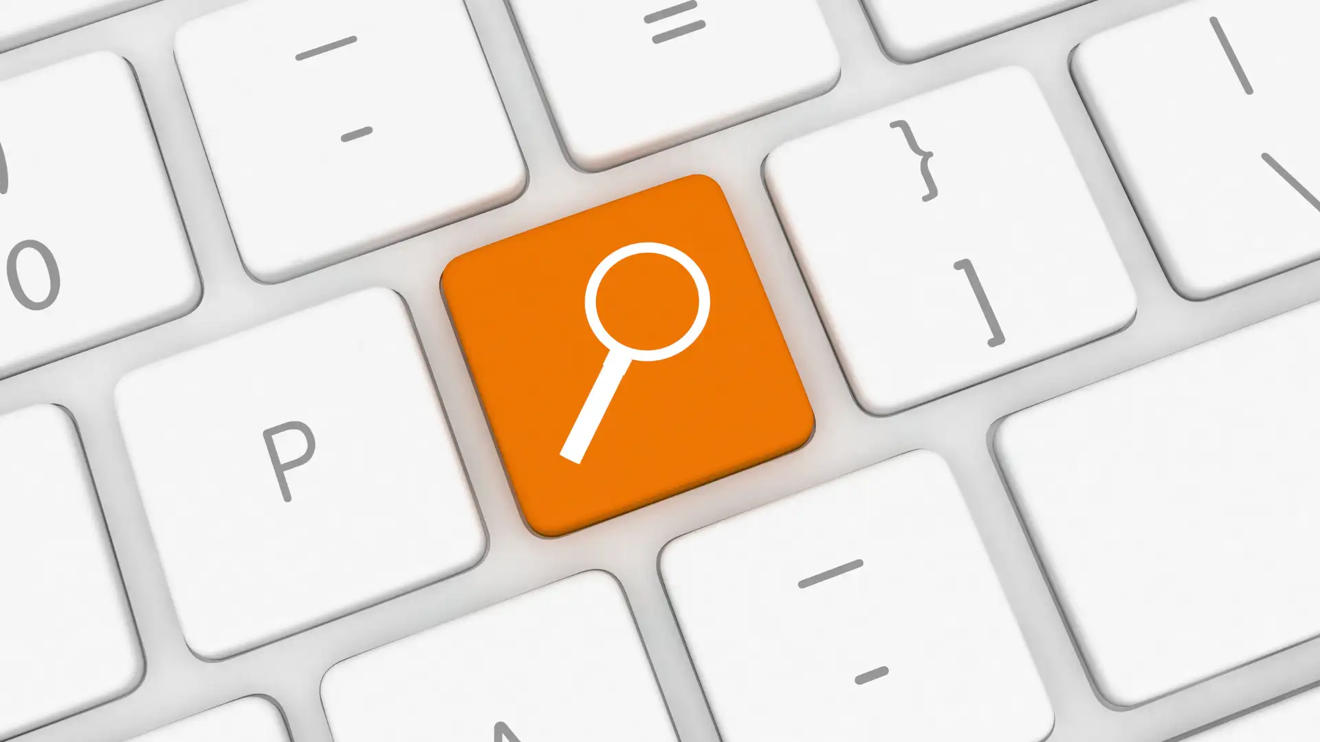 Orangefarbene Lupe auf Tastaturtaste symbolisiert interne Suchmaschine für Unternehmen