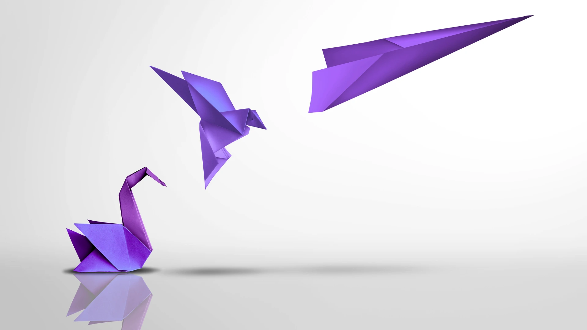 Drei lila Origami-Figuren als Symbol für die Entwicklung von Wissen