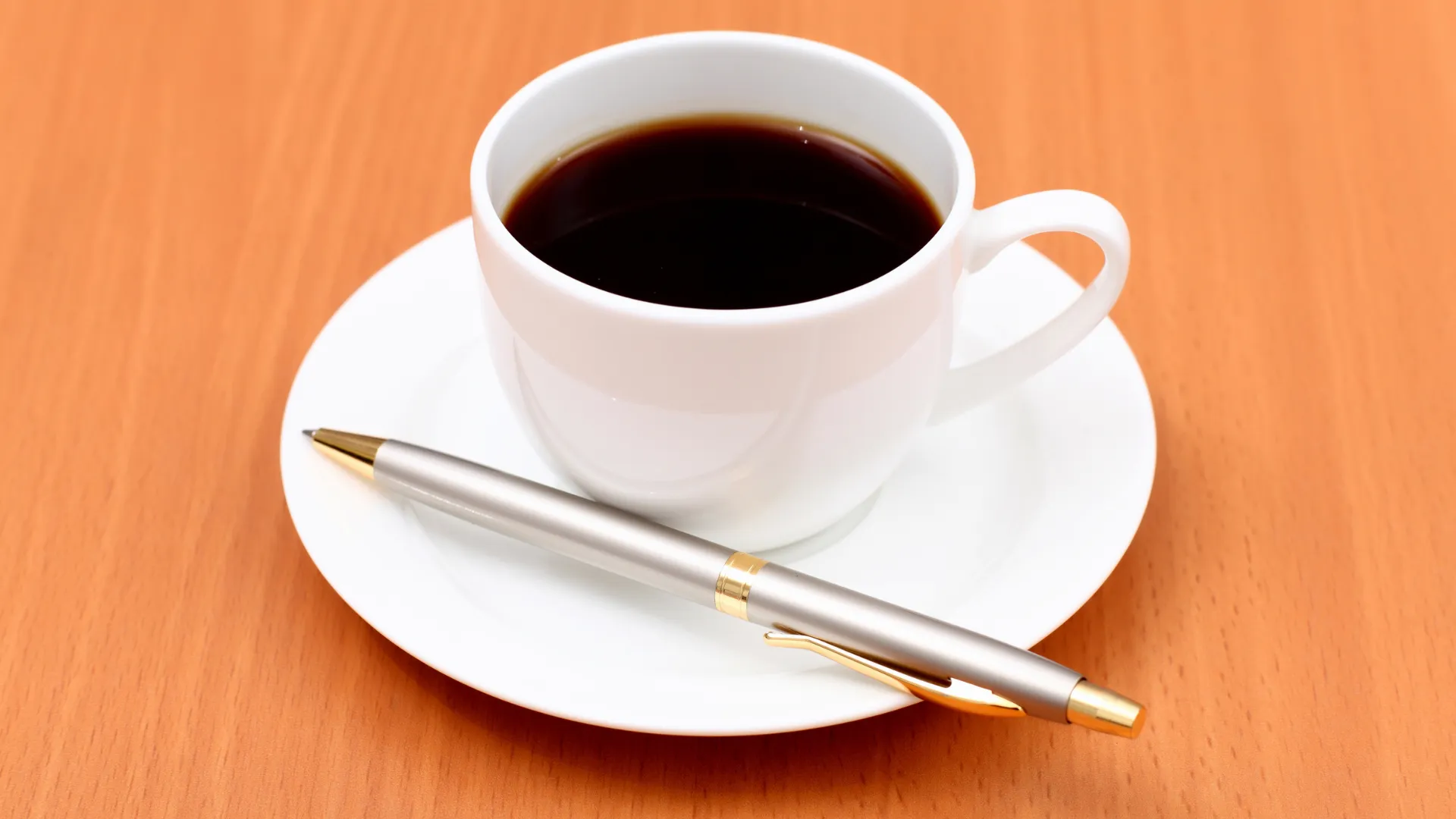 Coffee cup on orange wooden table
